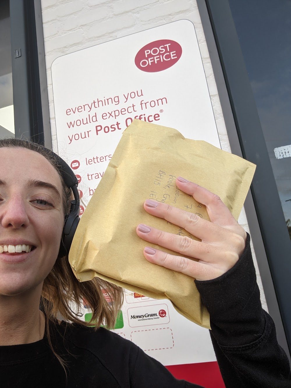Lucy smiling at the post office holding a parcel
