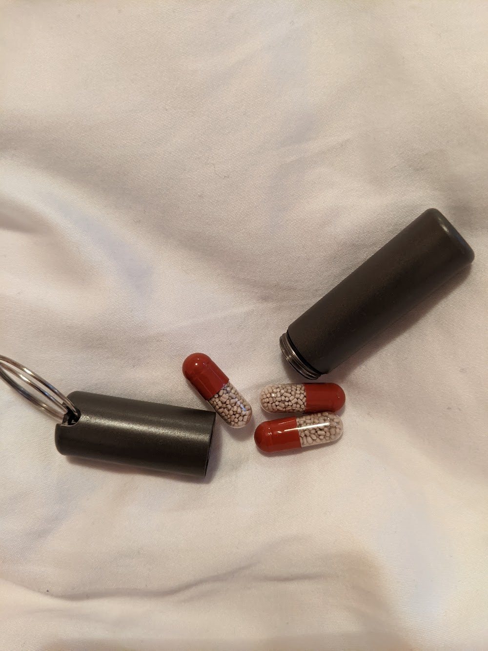 Prototype tubes and red capsules on a duvet