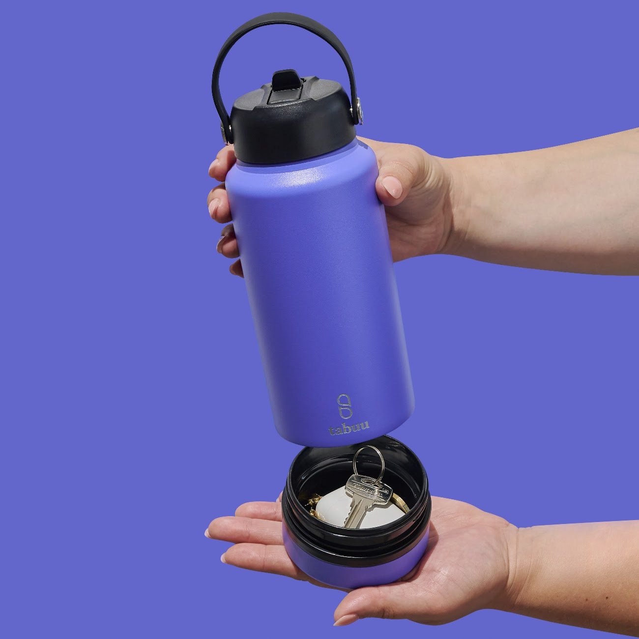 Hands holding a blue Tabuu bottle above its open base, which holds keys